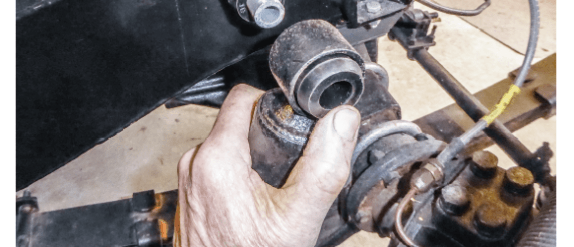 Image illustrating hands working on a leaf spring suspension system in a vehicle, closely focusing on the mechanics and tools involved, with text overlay expounding technical specifics regarding the spring knowledge.