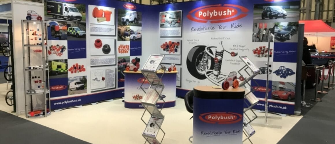 A display stand for polybush featuring display panels with images and information, a circular counter with brochures, and a banner reading "revolutionising your ride.