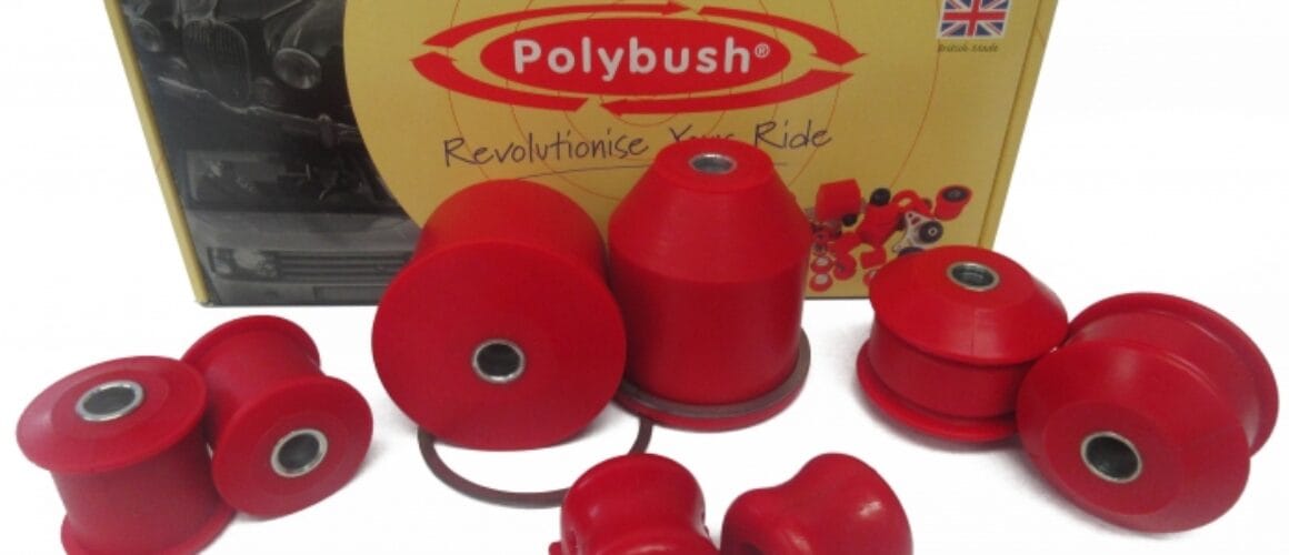 Various red polybush car suspension parts displayed in front of their packaging box, which features the brand logo and the union jack flag.